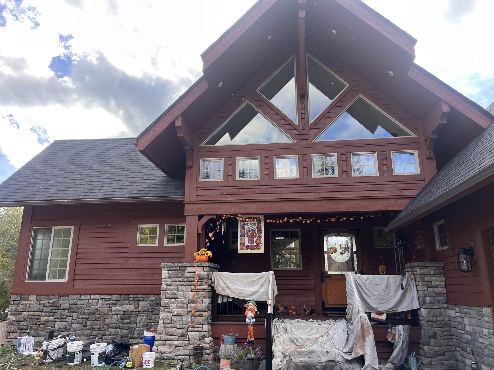 Log home front exterior painting with stone columns North Idaho